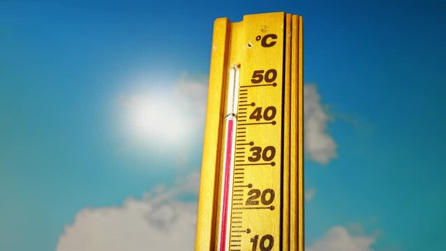 Hot summer day, the thermometer displays a high heatwave temperature of 40 degrees Celsius. A red alarm gives a warning of the extreme weather conditions caused by global climate change on Earth.