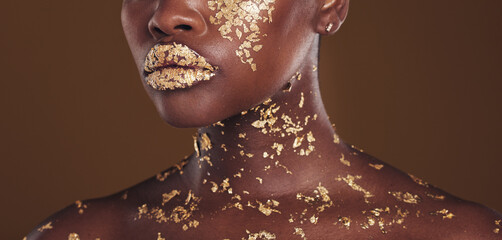 Beauty, lips and black woman with gold makeup on brown background for art, cosmetics and glitter...