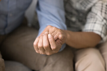 Old couple sharing stress, problems, going through crisis together. Senior husband and wife holding hands, giving comfort, support, empathy, consoling each other. Close up of arms