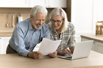Happy satisfied senior retired couple reading legal document, financial report, paper insurance agreement, getting good news, investment income, enjoying good successful retirement - obrazy, fototapety, plakaty