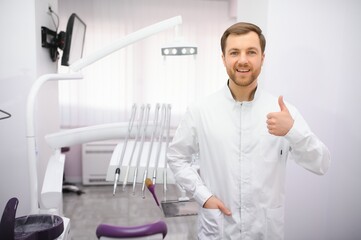 Naklejka na ściany i meble Young male dentist in clinic