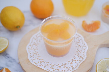Fresh orange juice in glass and fresh citrus fruits on white background.