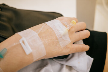 Arm of a  patient with a salt water hose on a hospital