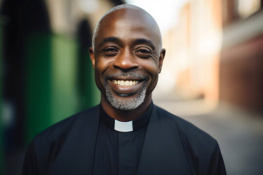 portrait of smiling poc priest wearing collar with blurred background