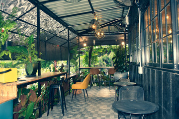 The wooden tables in front of the coffee shop and iron tables have soft cushions.