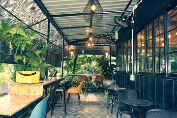 The wooden tables in front of the coffee shop and iron tables have soft cushions.