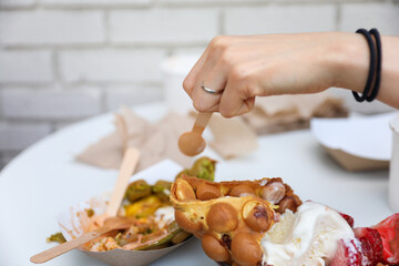 Hands and utensils gather around, embracing the communal spirit of a potluck dinner. Symbolizing unity, sharing, and indulgence as they enjoy a variety of desserts