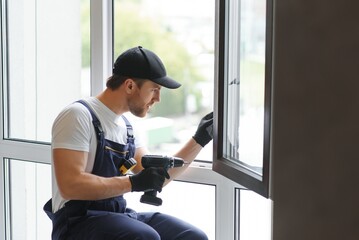 service man installing window with measure tape