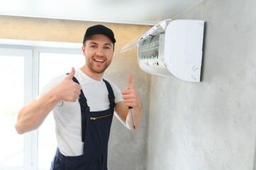 Happy Male Technician Repairing Air Conditioner.