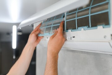 specialist cleans and repairs the wall air conditioner