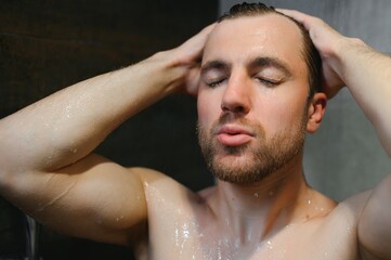 relaxing time.fresh shower concept.under good looking man is under water drops