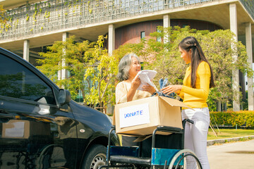 Elderly mother and her asian philanthropist daughter drive to the shelter to donate wheelchairs and...