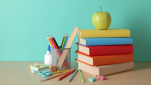 School background. School supplies, a book stack, and a green apple are on the desk.