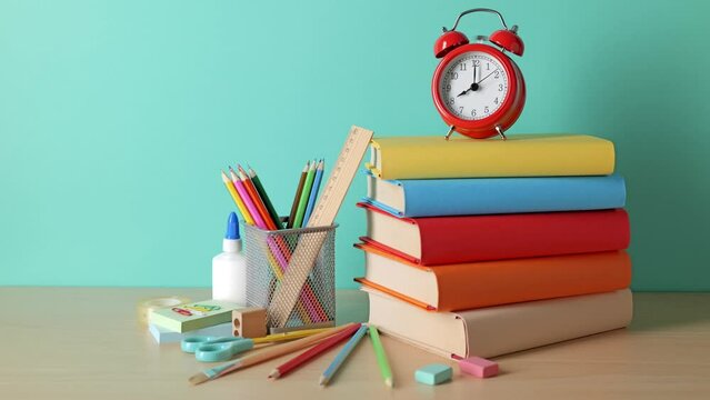 School background. School supplies, a book stack, and an alarm clock are on the desk.
