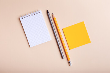 Stationery from above. Checkered notepad mockup, orange and grey pencils, orange  paper for notes...
