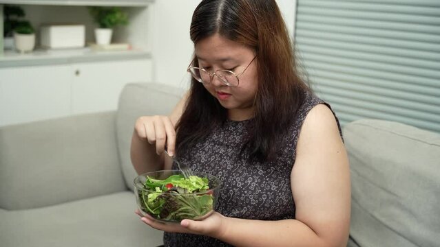 Asian Overweight woman dieting Weight loss eating fresh fresh homemade salad healthy eating concept Obese Woman with weight diet lifestyle.