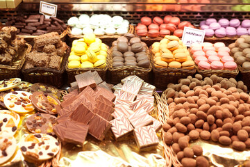 French macarons and other sweets on counter of market