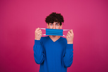Funny attractive in a protective mask. Pink background.