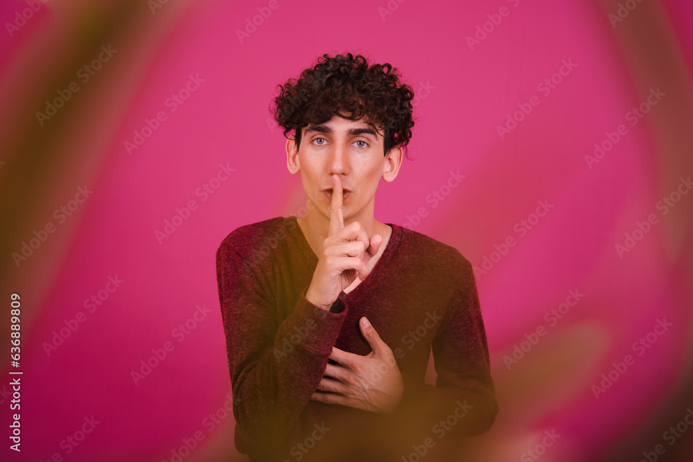 Wall mural attractive guy posing on a pink background. the student is happy and sad.