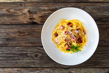 Spaghetti carbonara on wooden table
