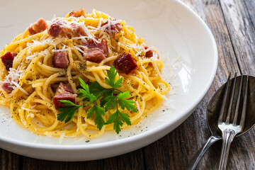 Spaghetti carbonara on wooden table
