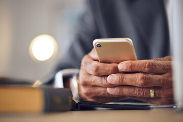 Closeup hand, typing and a person with a phone for communication, email check or contact. Desk, work and a man with a mobile in an office for an online app, connection and reading a notification