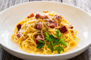 Spaghetti carbonara on wooden table
