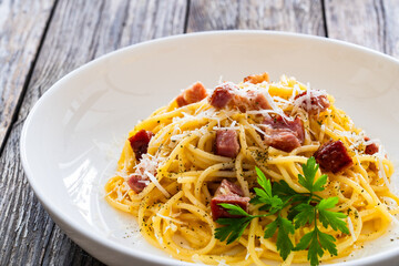Spaghetti carbonara on wooden table
