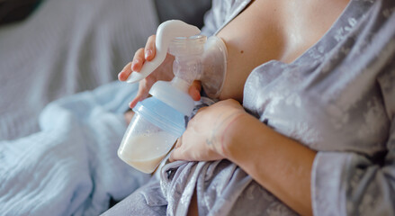 A mom expressing breast milk with a breast pump - 636893639
