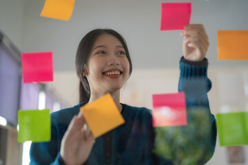 Young confident Businesswoman planning with adhesive notes in creative office.