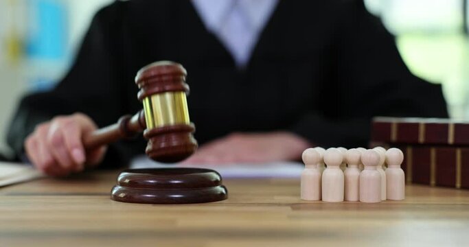 Female judge knocking gavel on sound block renders verdict in courthouse. Guilty and accomplices in commission of crime slow motion