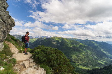 Fototapeta premium A man in a red shirt, a traveler in the Tatra mountains on a summer day.