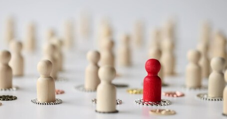 Hand puts red figure of human on gear surrounded by white figures on mechanisms. Leadership with nonconformity and different opinion concept slow motion