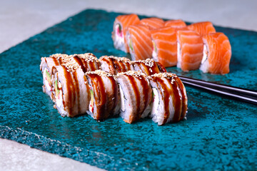 delicious sushi rolls on a stone blue background