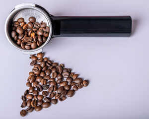 Coffee beans are in a boom arm for coffee machine and on a white table