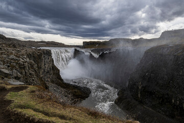 The most powerful waterfall in europe, the dettifoss on iceland in summer under a dramatic sky with dark storm clouds -areal view