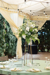 A beautiful vase of flowers on a table in a luxury restaurant. Wedding decorations