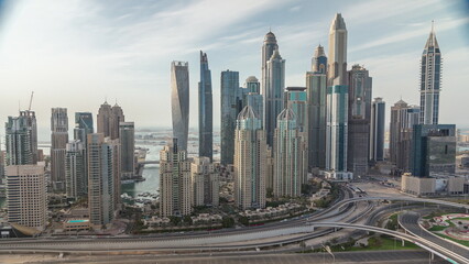 Naklejka na ściany i meble Skyscrapers of Dubai Marina near intersection on Sheikh Zayed Road with highest residential buildings all day timelapse