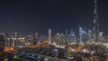 Panorama showing Dubai's business bay towers aerial night timelapse. Rooftop view of some skyscrapers