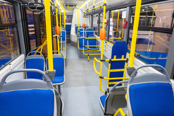 City bus interior. Public transport. Modern trolleybus view inside. New bus with seats for disabled. Tram interior without passengers. Bus with yellow handrails. Modern public transport © Grispb