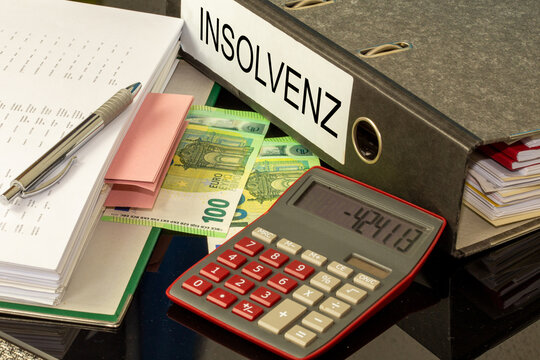 Symbolbild Insolvenz: Ordner, Taschenrechner und Euro-Banknoten