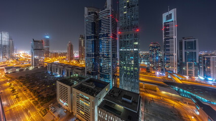 Fototapeta na wymiar Aerial view of Dubai International Financial District with many skyscrapers all night timelapse.