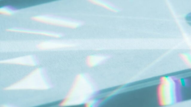 Optical Lens System Creates a Glare. Loop. The optical lens system creates a series of bright, changing geometric highlights on a light surface