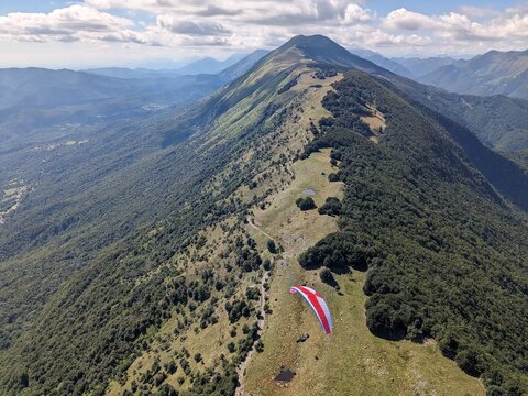Paragliding beauty of free flying in Julian Alps, big mountains flying at the cloudbase of cumulus clouds,scenic aerial panorama landscape view,Slovenia Stol mountain Europe