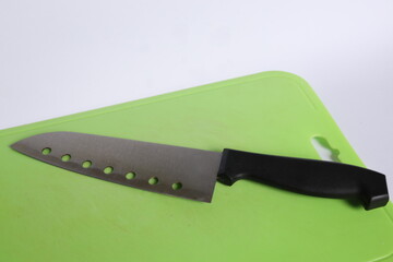 An kitchen knife on green cutting board isolated