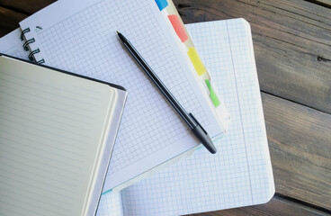 open notebooks with pens. Education at school - a pen and notebooks on a wooden table.