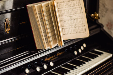 Close up of an old antique piano and a book of sheet music