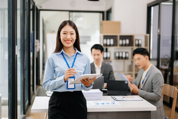Fototapeta premium Young attractive Asian female office worker business suits smiling at camera in office .