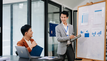 Group of young Asian business people discussing business plan at modern startup in creative business discussing work modern office building.