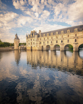 Le chateau de Chenonceau sur le bord de la Loire en France , vue verticale sous un ciel bleu parsem&eacute; de nuages avec son reflet dans l'eau. 
